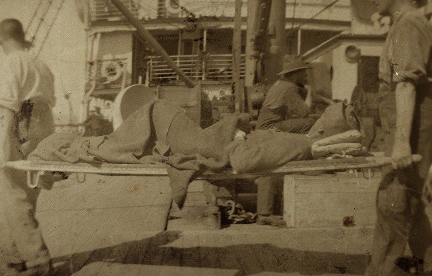 A wounded soldier being stretchered on a hospital ship off Gallipoli