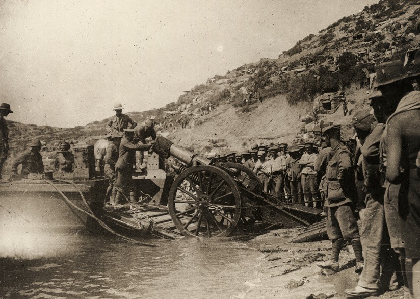 Troops unload a British 6 inch BL Siege Howitzer from a specialized artillery landing barge at ANZAC Cove, Gallipoli, 1915.
